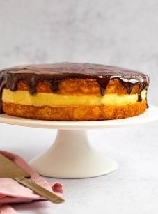 Boston cream pie on a raised serving platter.