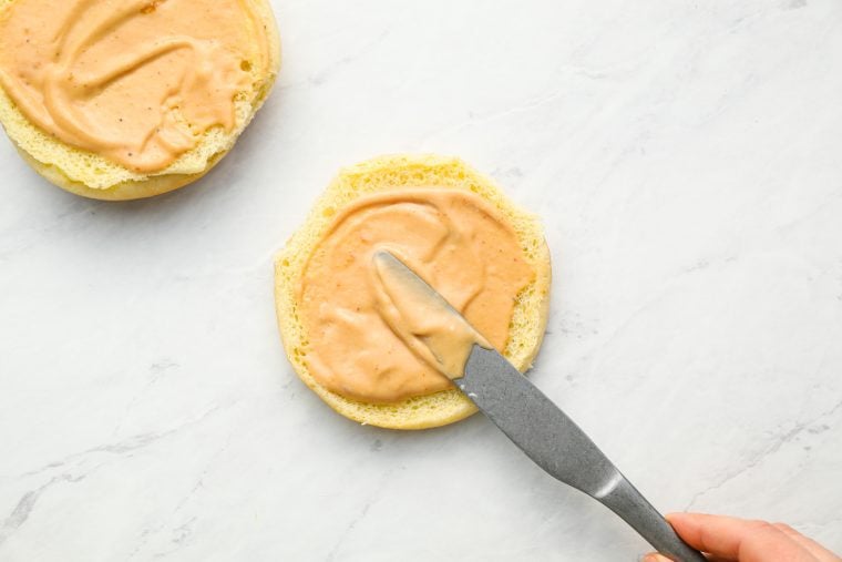 spreading sauce on both sides of bun