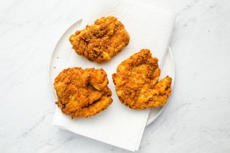 cooked chicken on paper towel-lined plate