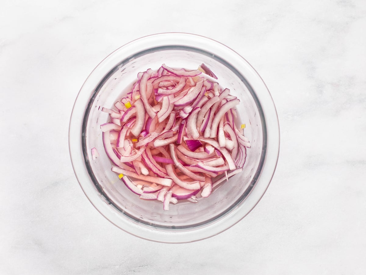 Onions in a small bowl covered with vinegar and water.