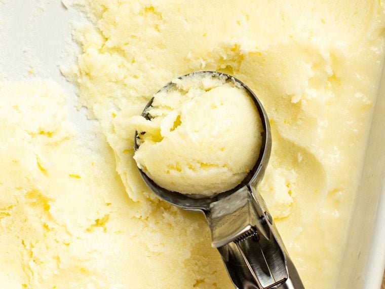 scooping lemon ice out of container to serve