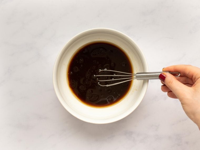 Whisking soy sauce, oyster sauce, sesame oil, and water in medium bowl