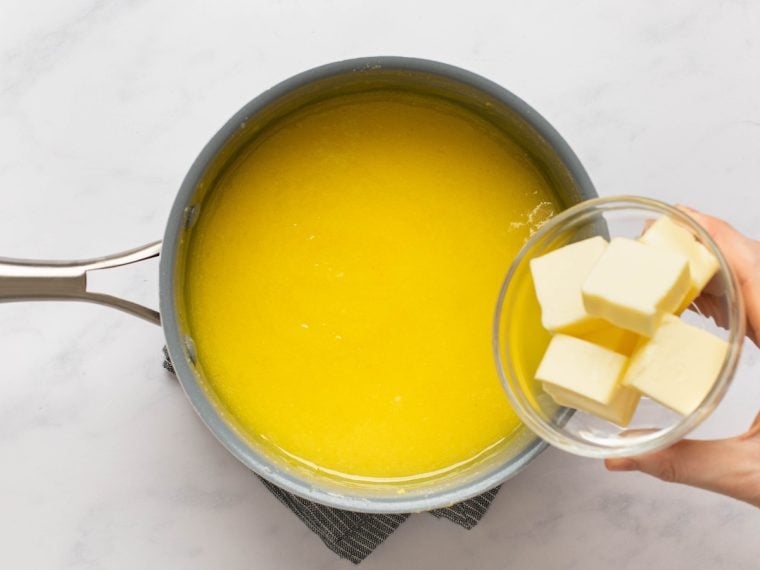 adding butter to the mixture in the saucepan