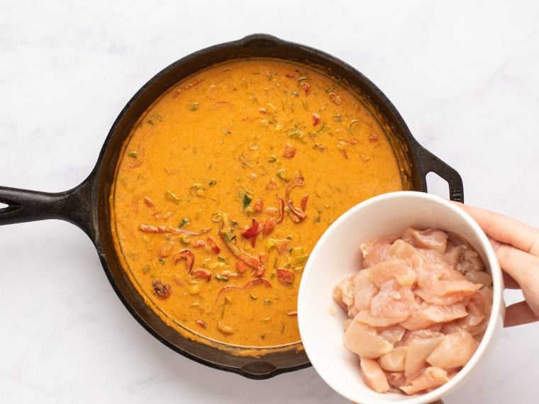 adding the chicken to the panang curry sauce