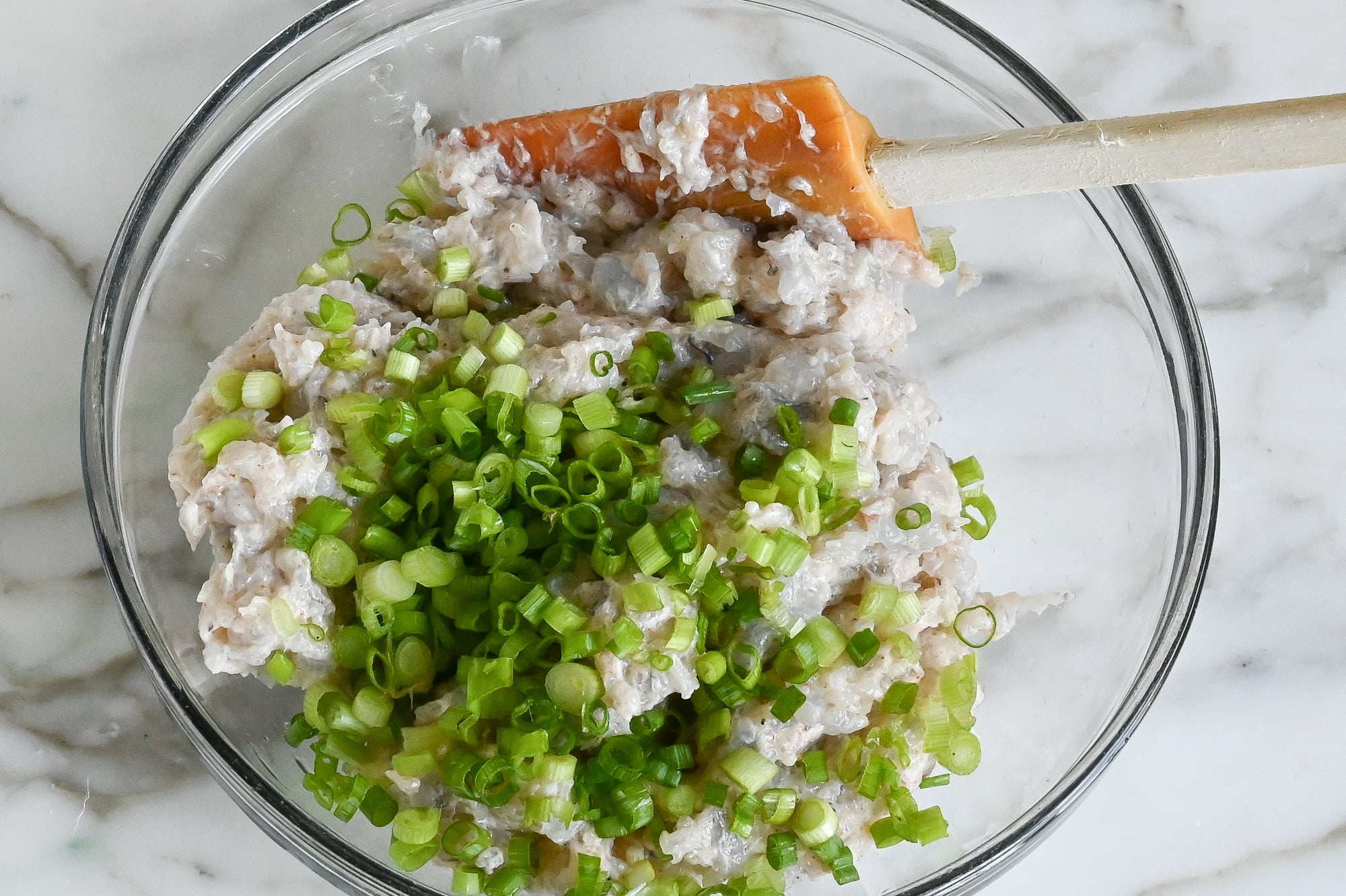 Shrimp mixture in bowl with chopped scallions.