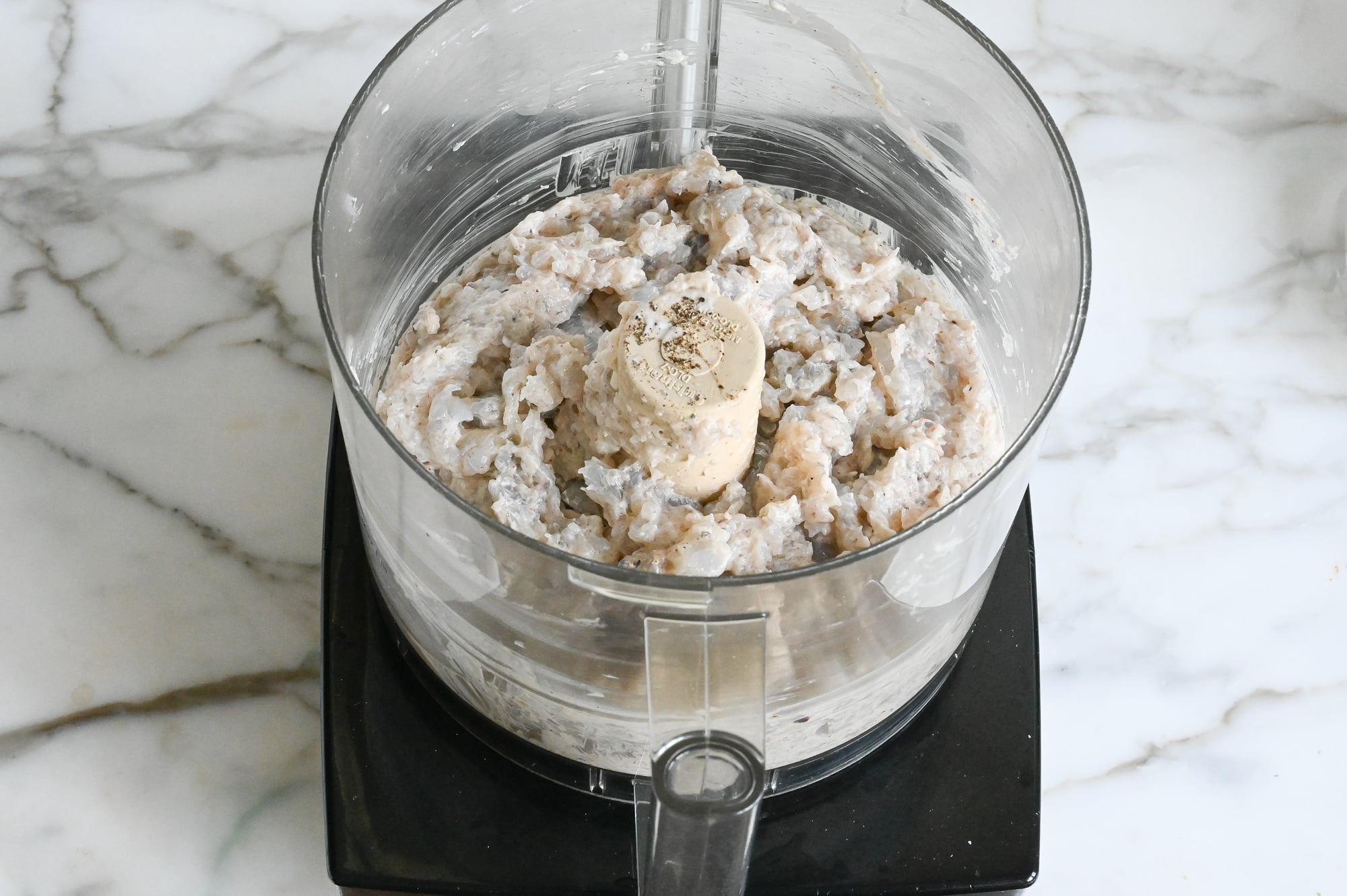 Chopped shrimp burger mixture in food processor.