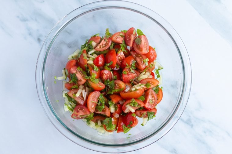 Tomato-cucumber salad in a glass bowl.