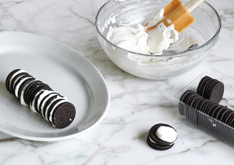 stacking the cookies with whipped cream