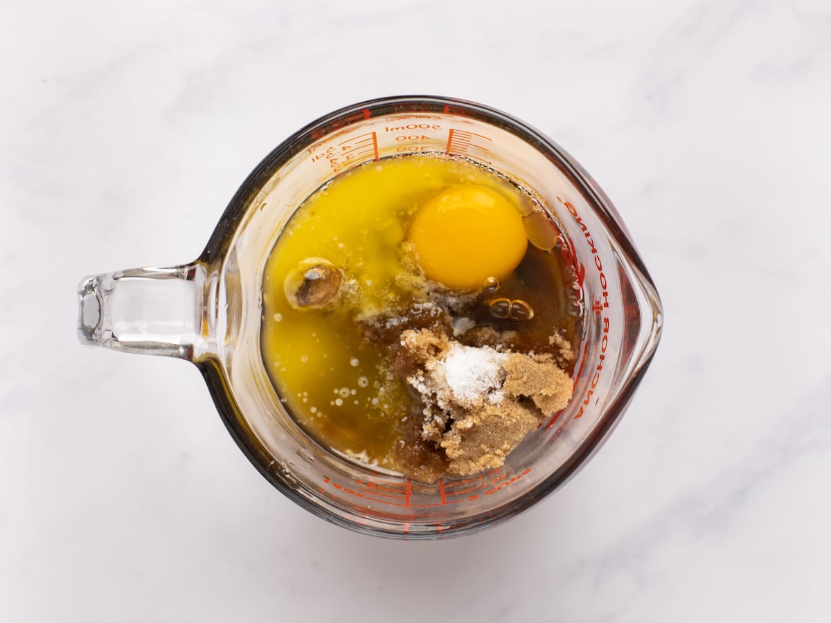 brown sugar, maple syrup, butter, egg, vinegar, vanilla, and salt in medium bowl with pouring spout