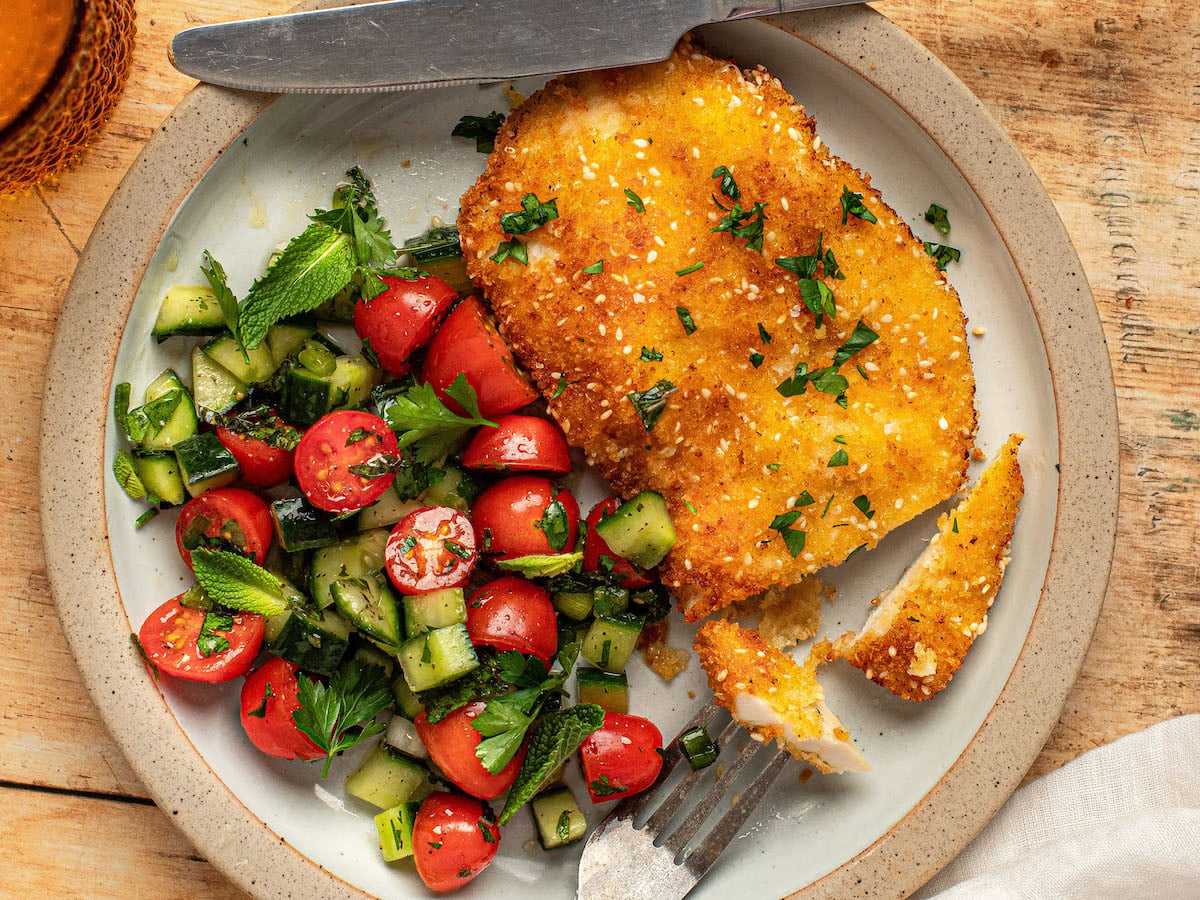 chicken schnitzel on plate with israeli salad
