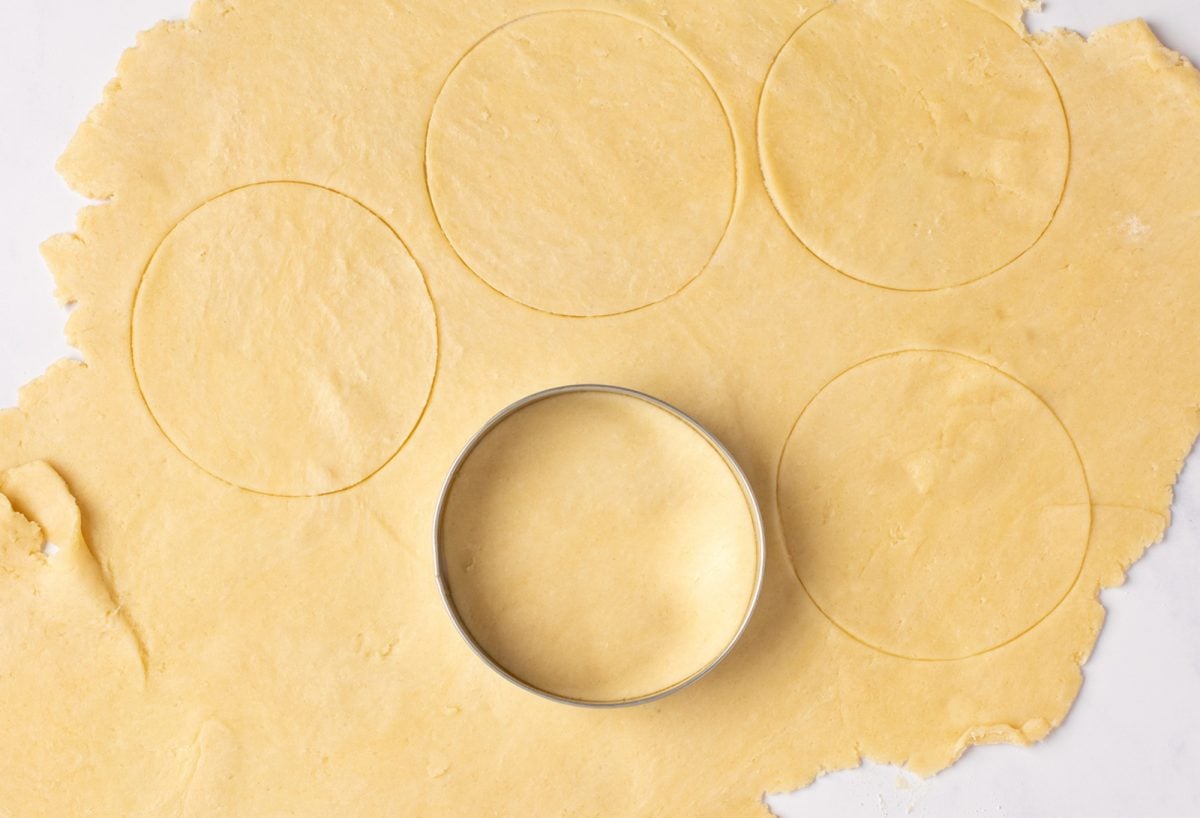 Cutting butter tart dough with cookie cutter.