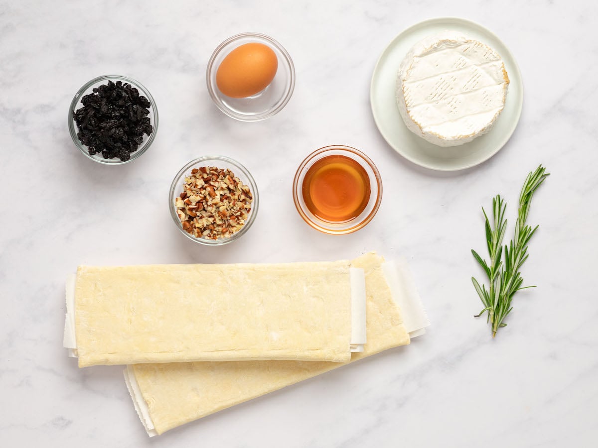 Baked brie ingredients including egg, puff pastry, and honey.
