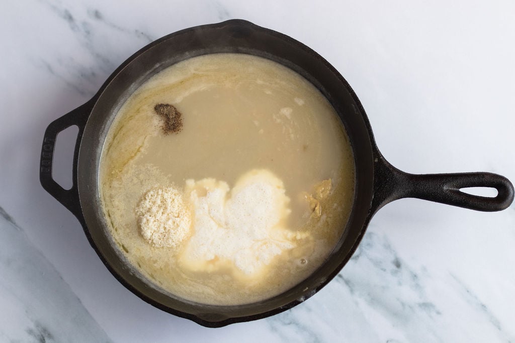 heavy cream, salt, pepper, mustard, and Parmigiano Reggiano added to skillet.