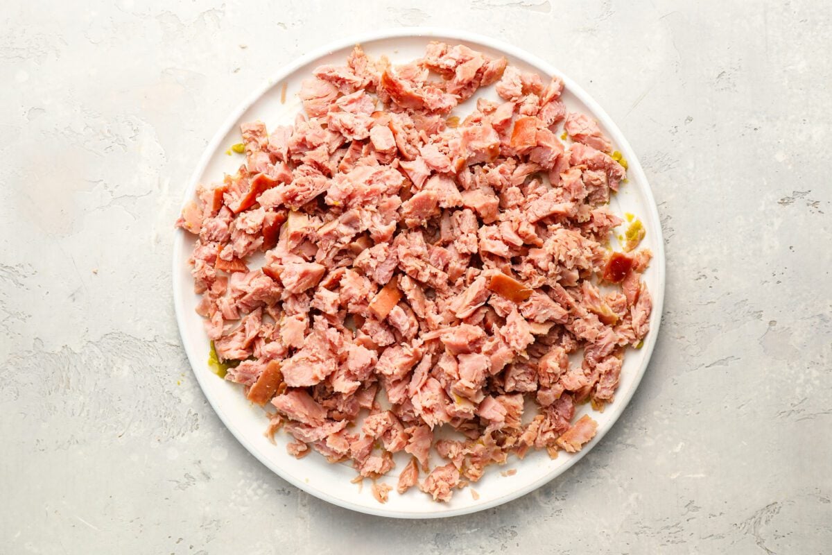 Shredded ham steak on a white plate.