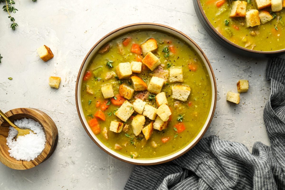 bowls of split pea soup topped with croutons.