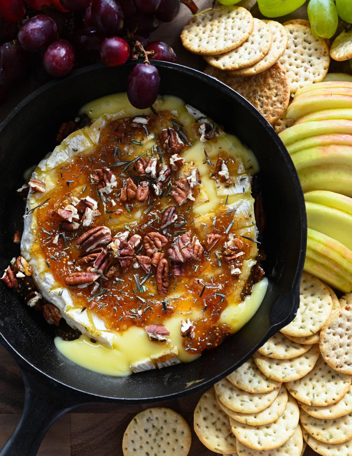 baked brie in skillet with crackers and fruit