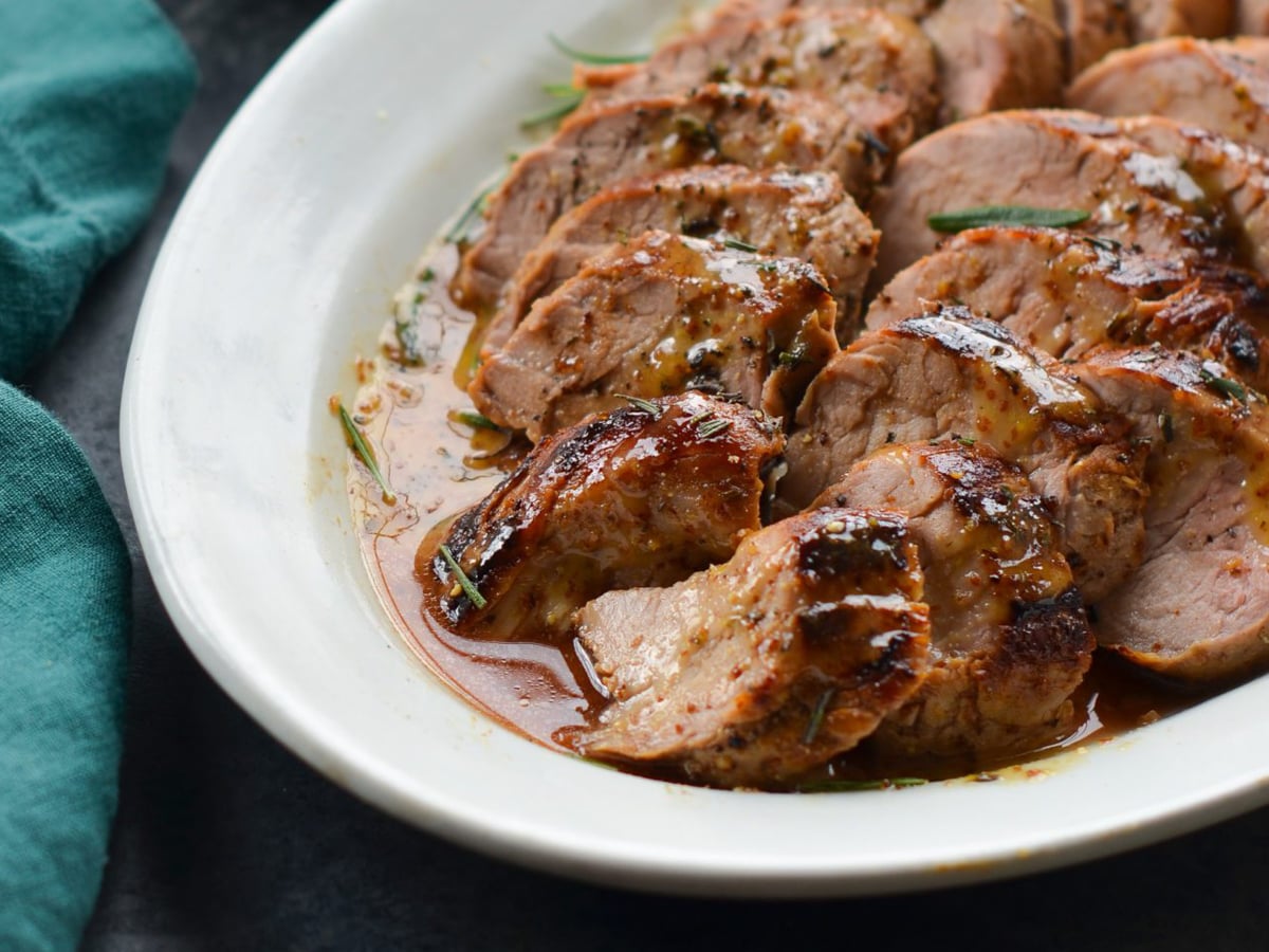 sliced pork tenderloin on plate.