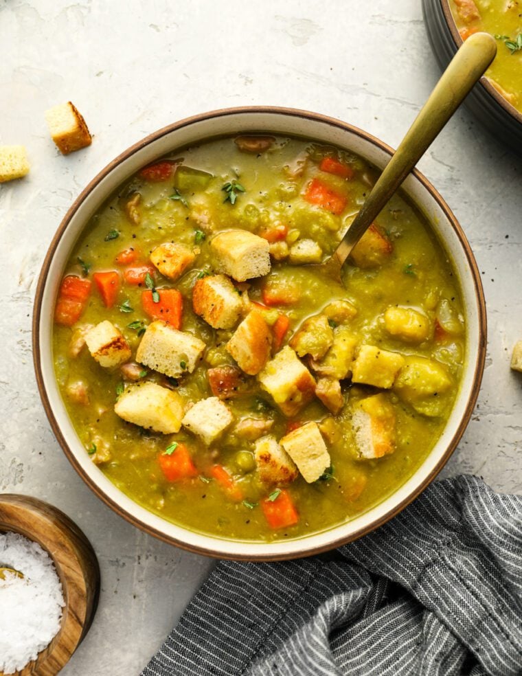 Bowl of split pea soup topped with croutons.