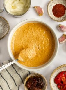 sun-dried tomato and red pepper aioli in a bowl with ingredients surrounding it