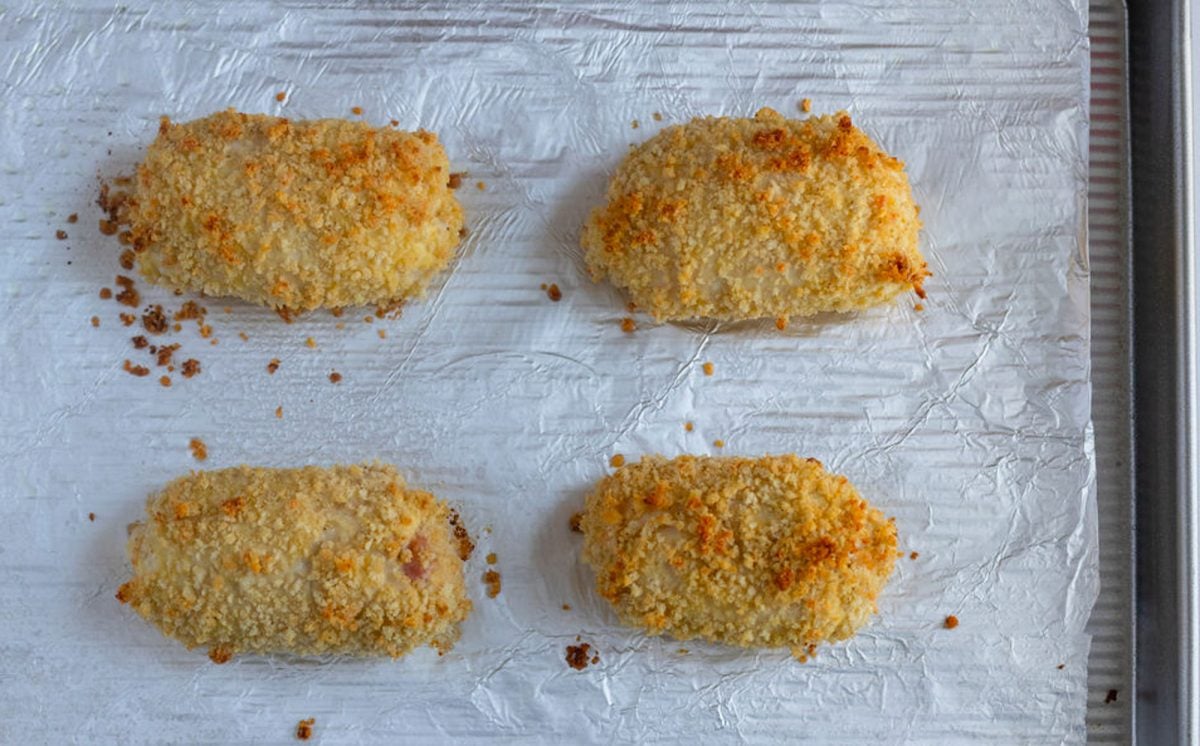 baked chicken cordon bleu on foil-lined baking sheet