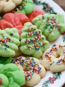 Colorful spritz cookies on a Christmas plate.