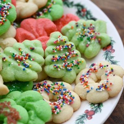 Colorful spritz cookies on a Christmas plate.