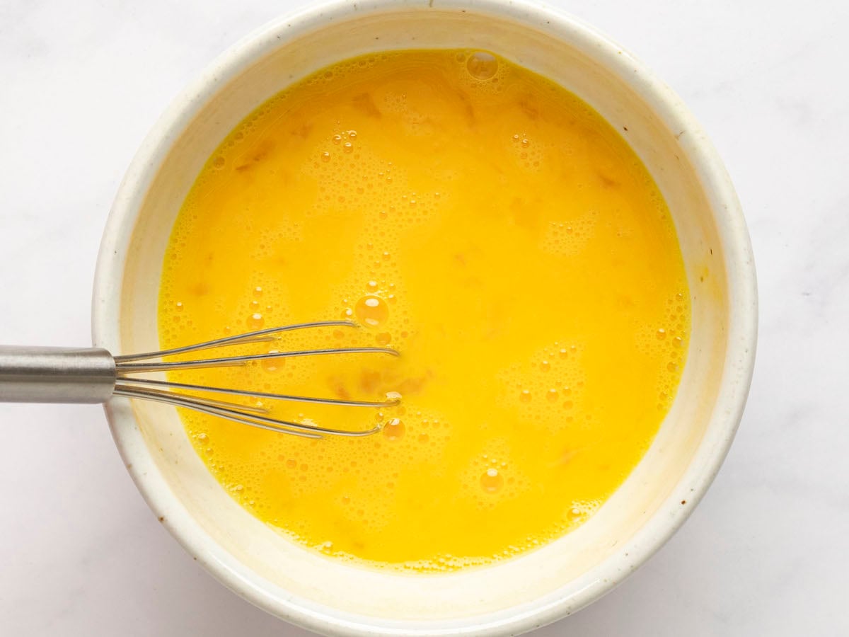 whisking eggs in a bowl.