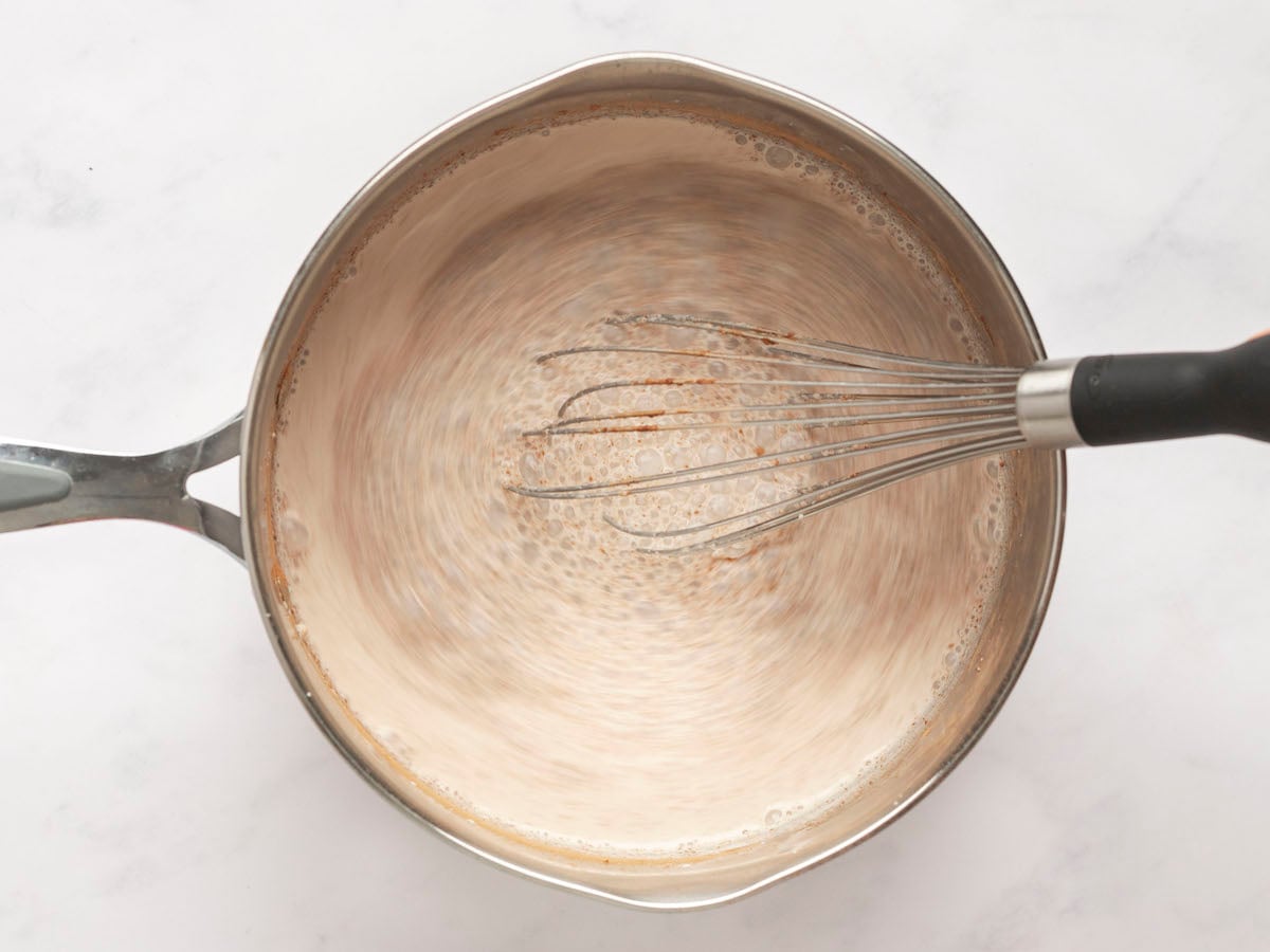 whisking milk, cream, brown sugar, cocoa powder, and salt over high heat.