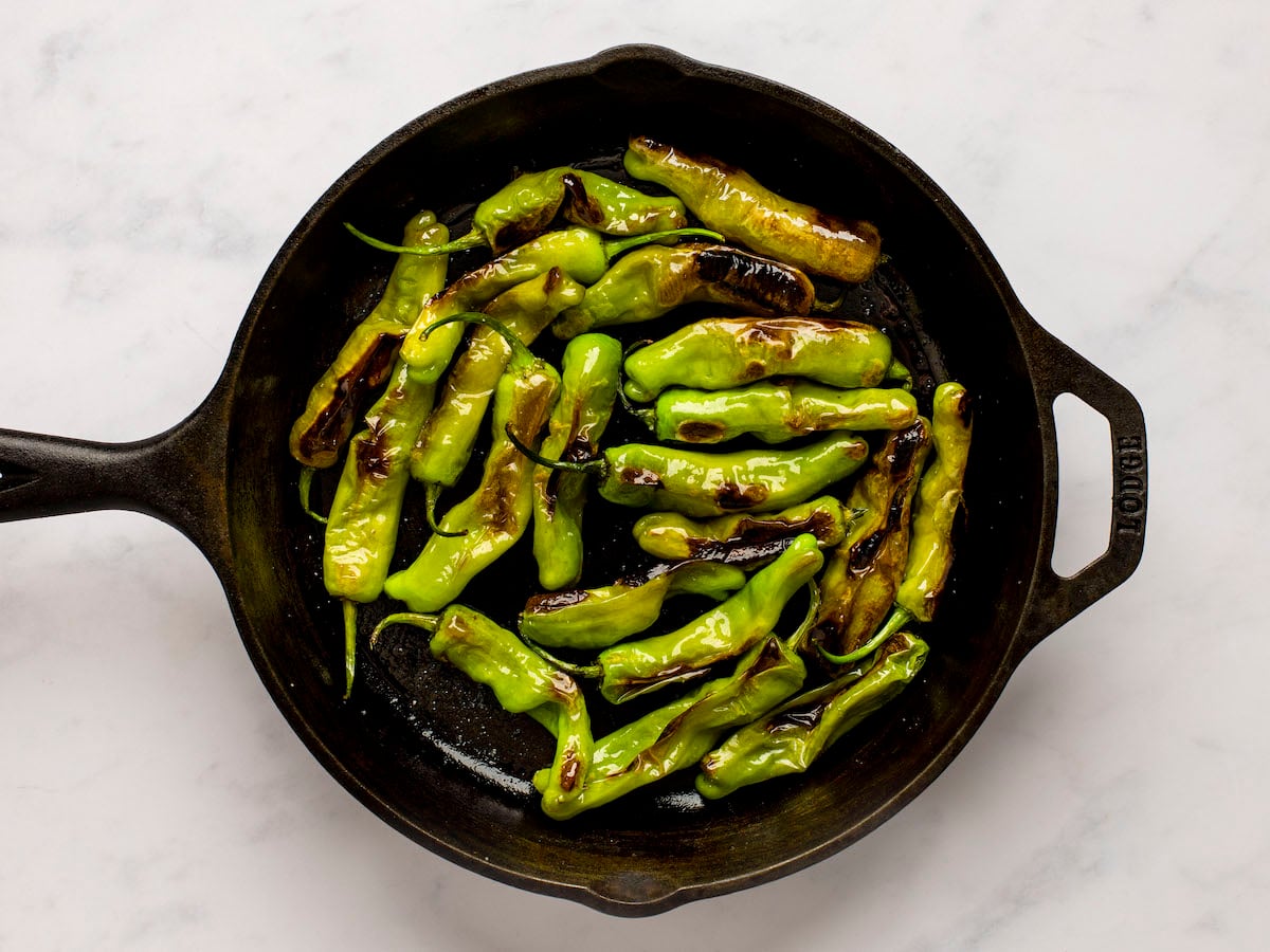 fully cooked, blistered shishito peppers in skillet