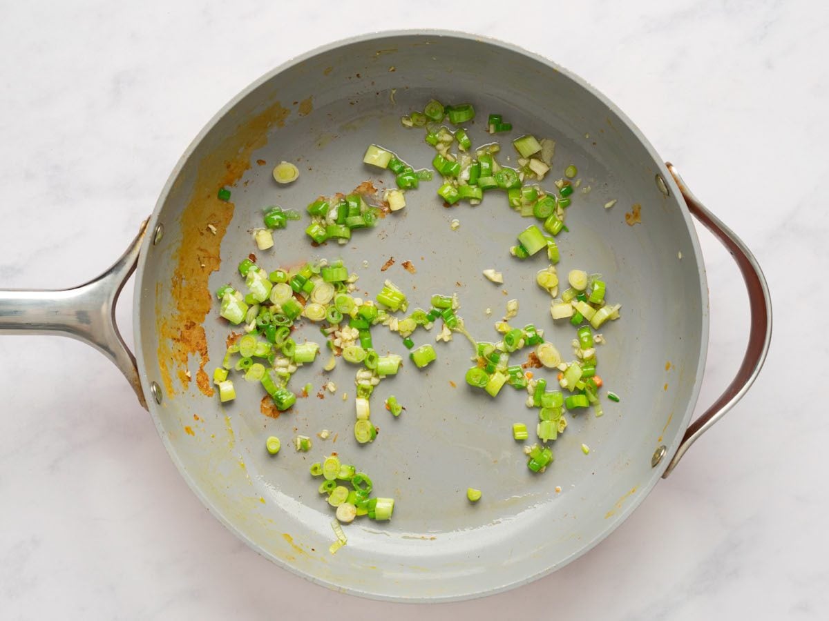 light green scallions in non-stick skillet.