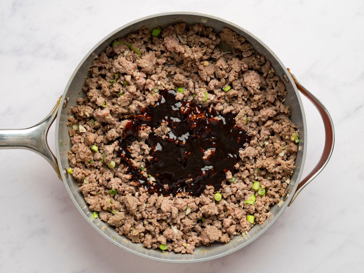 adding the hoisin mixture to the beef.