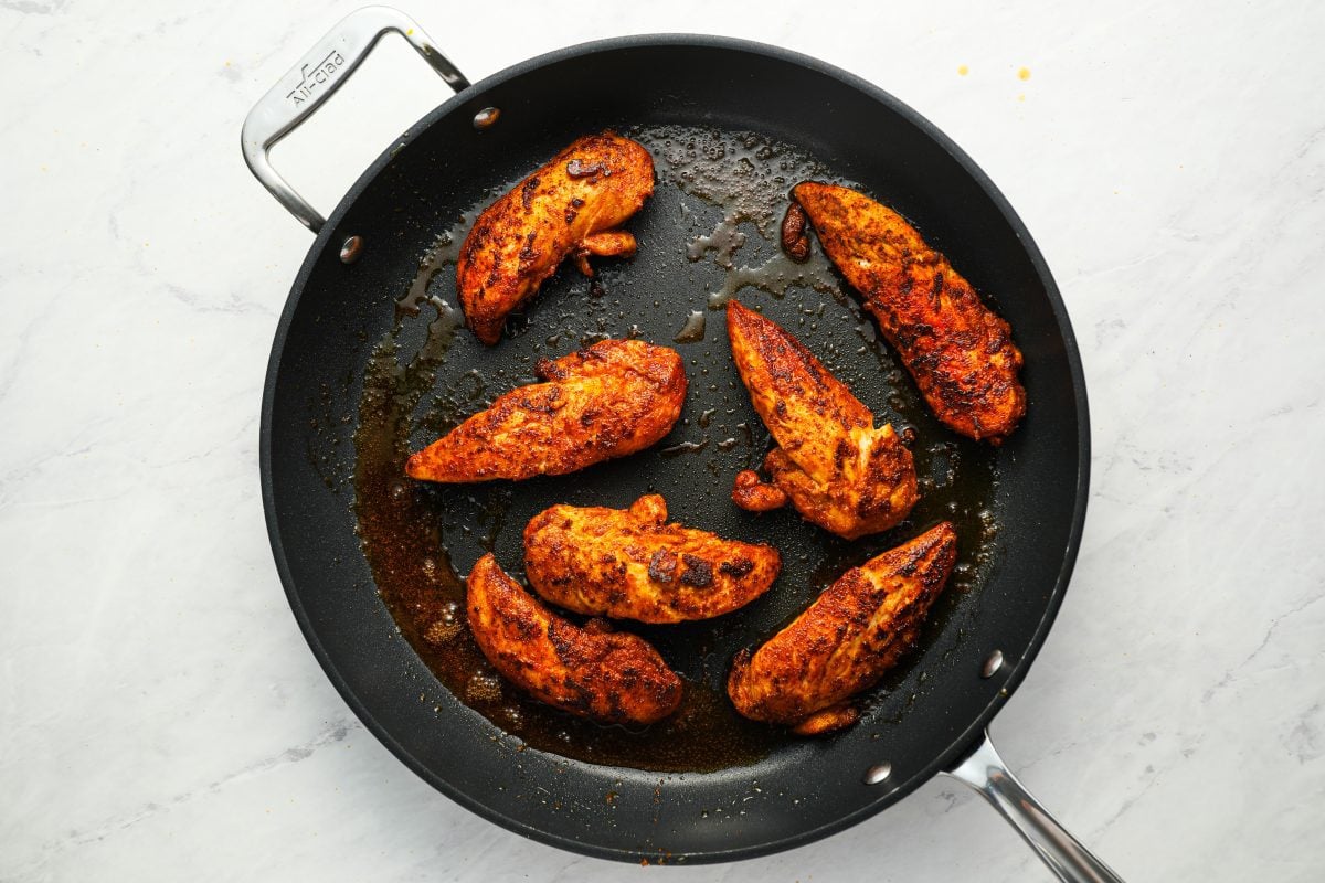 cooking chicken tenderloins in skillet.