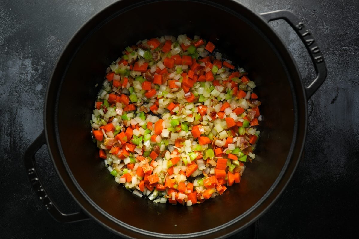vegetables and bacon cooking in pot.