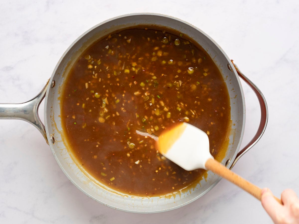 thickened orange chicken sauce in skillet.
