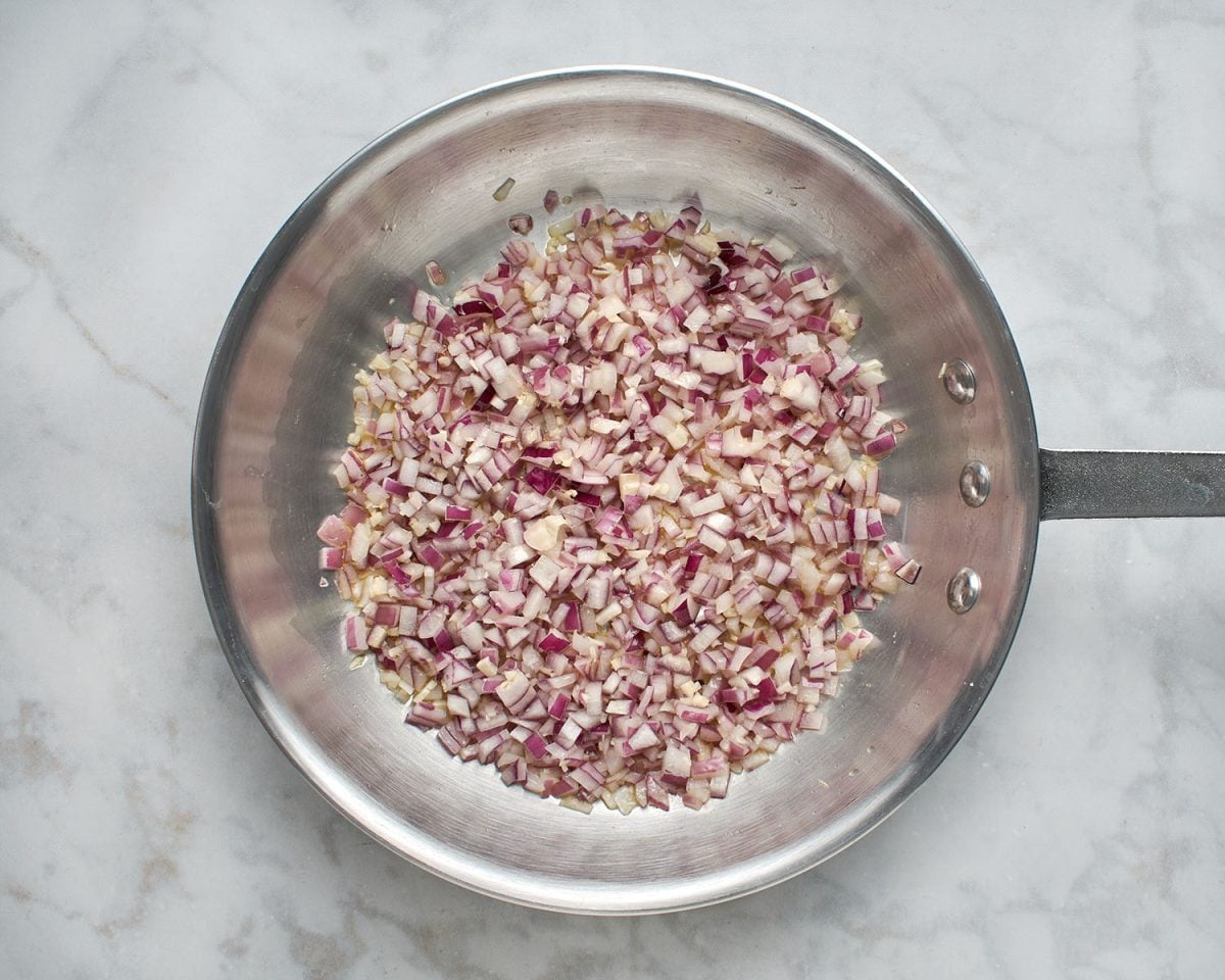 cooking the red onions and garlic in olive oil in a skillet