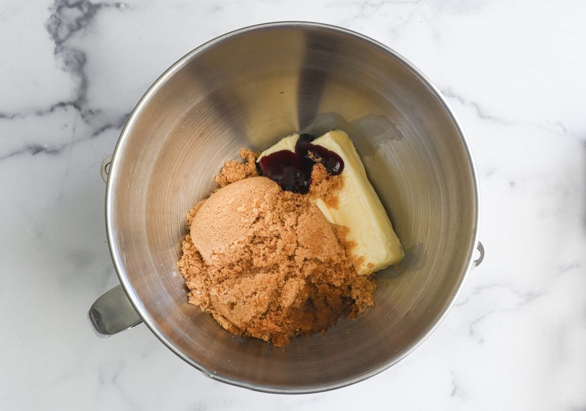 butter, vanilla, brown sugar, and red food coloring in bowl of electric mixer.