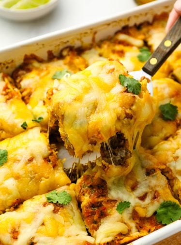 Serving slice of Mexican lasagna.
