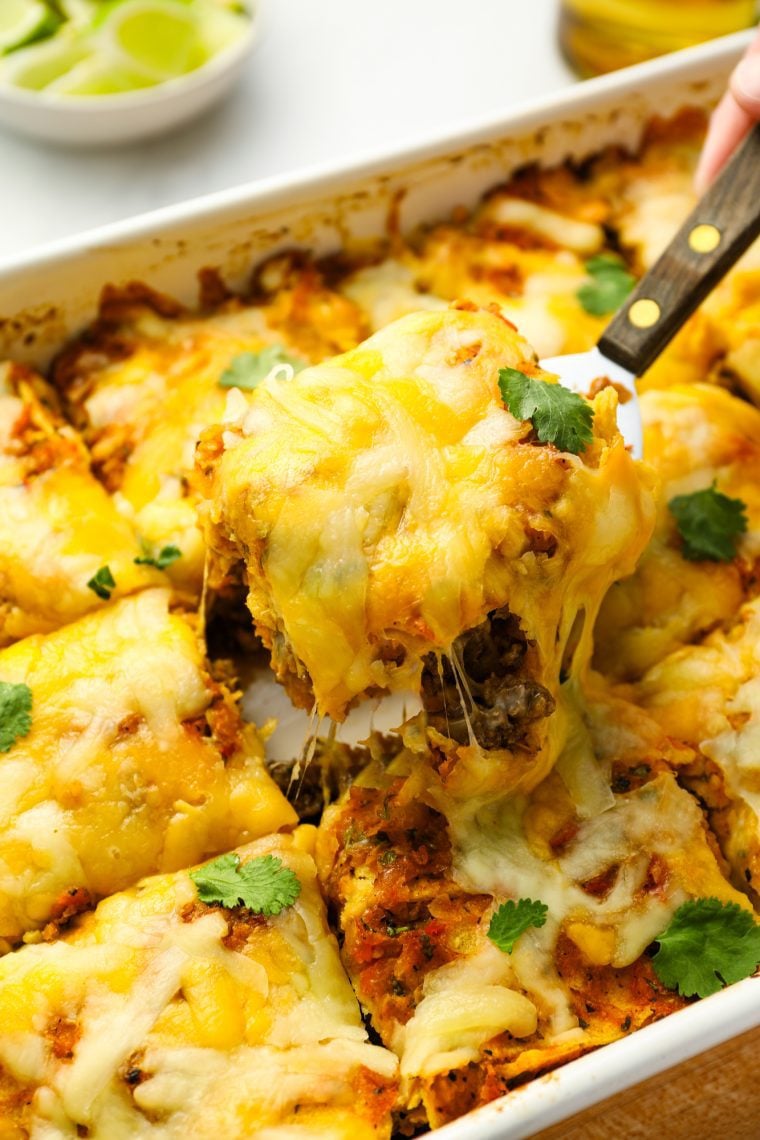 Serving slice of Mexican lasagna.