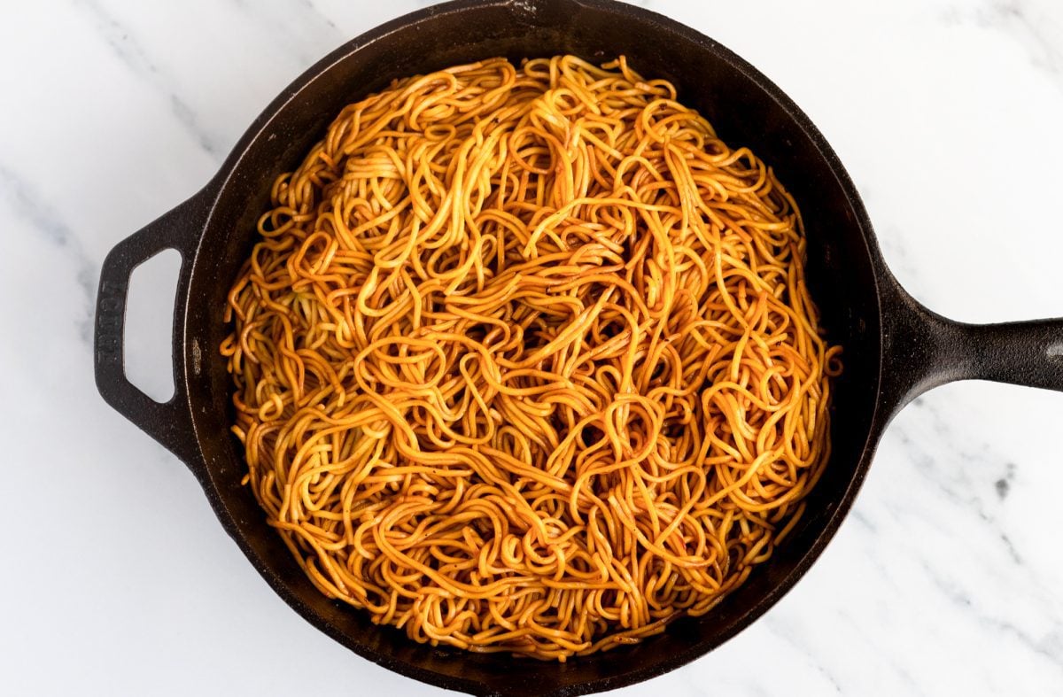 noodles and sauce mixed together in cast iron skillet