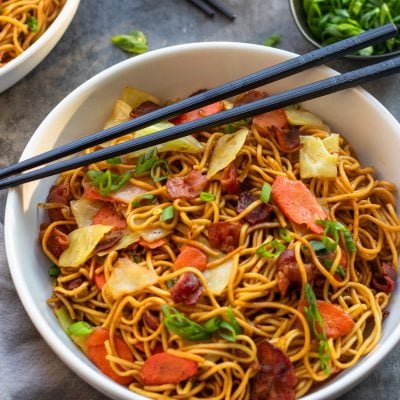 bowl of yakisoba with scallions and chopsticks