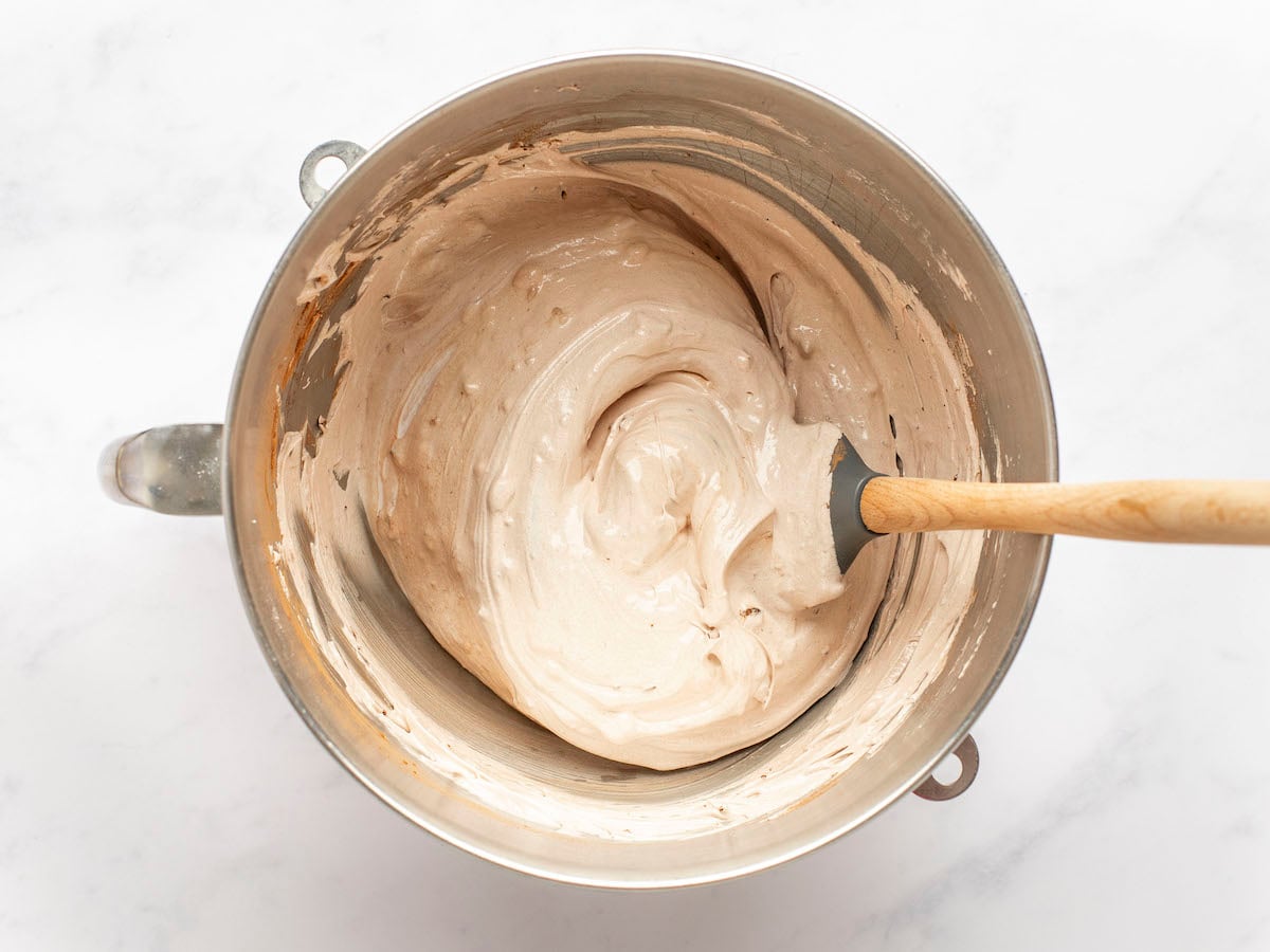 chocolate pavlova mixture in mixing bowl with rubber spatula.