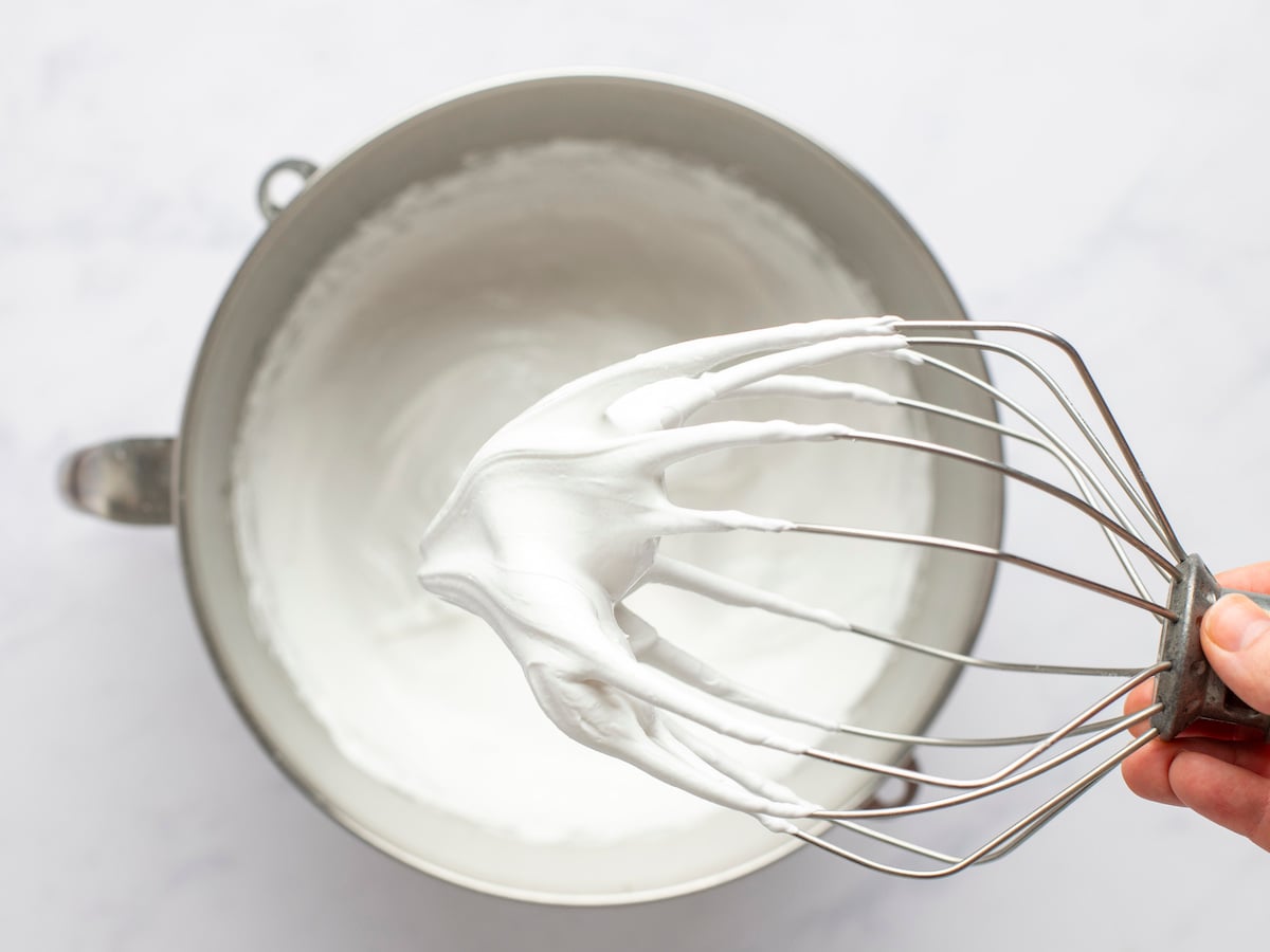 Egg white, salt, cream of tartar, and sugar beaten in mixing bowl with stiff peaks formed.