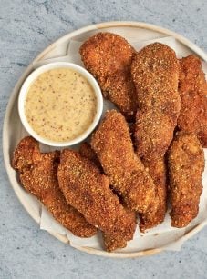 pecan crusted chicken tenders on plate with honey mustard sauce