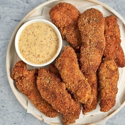 pecan crusted chicken tenders on plate with honey mustard sauce