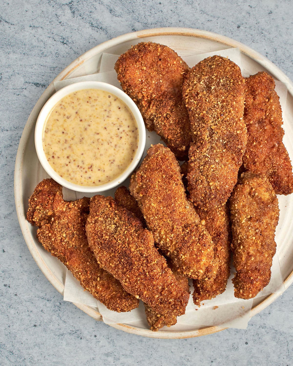 pecan crusted chicken tenders on plate with honey mustard sauce