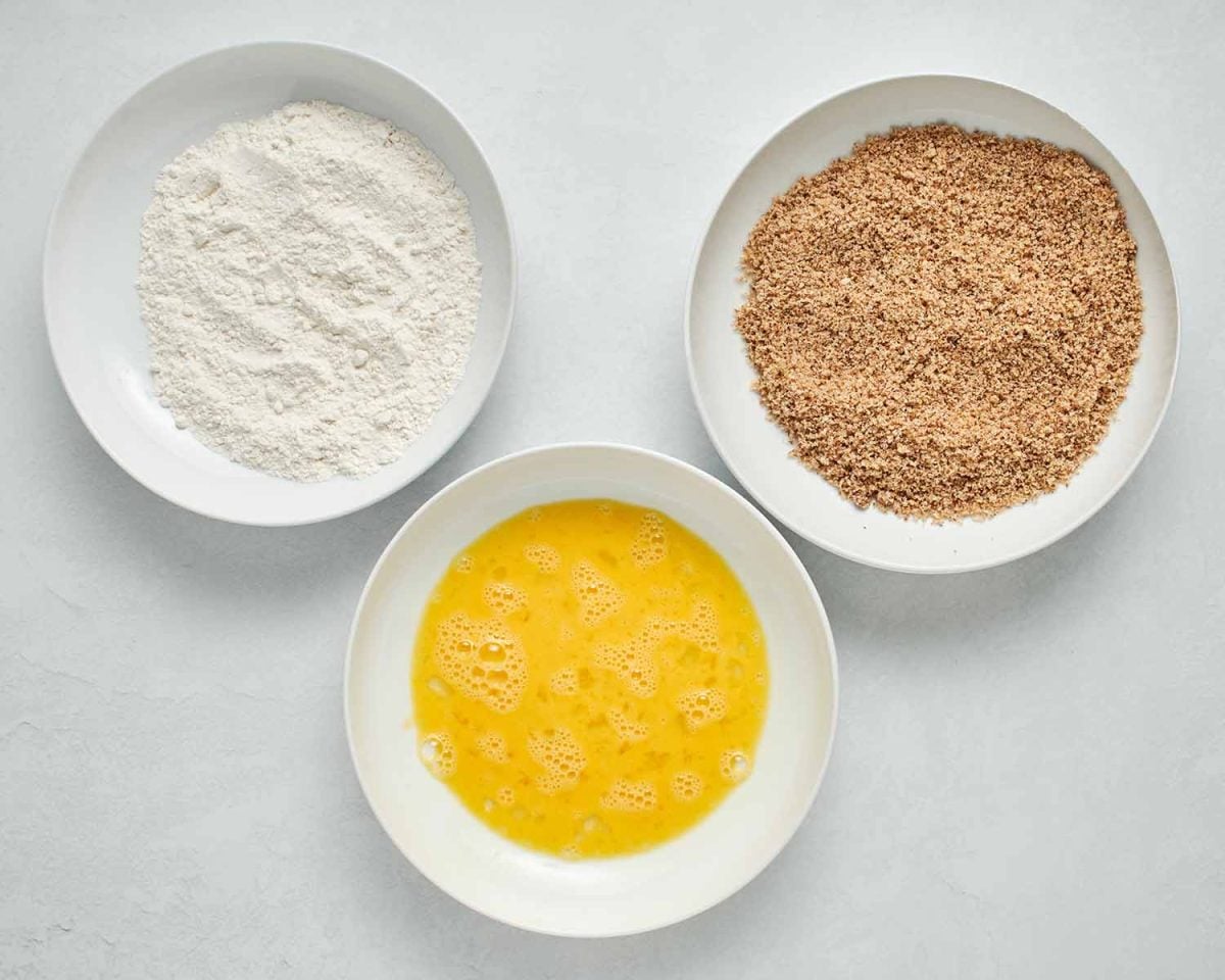 bowls of eggs, flour, pecan breading set up as a breading station