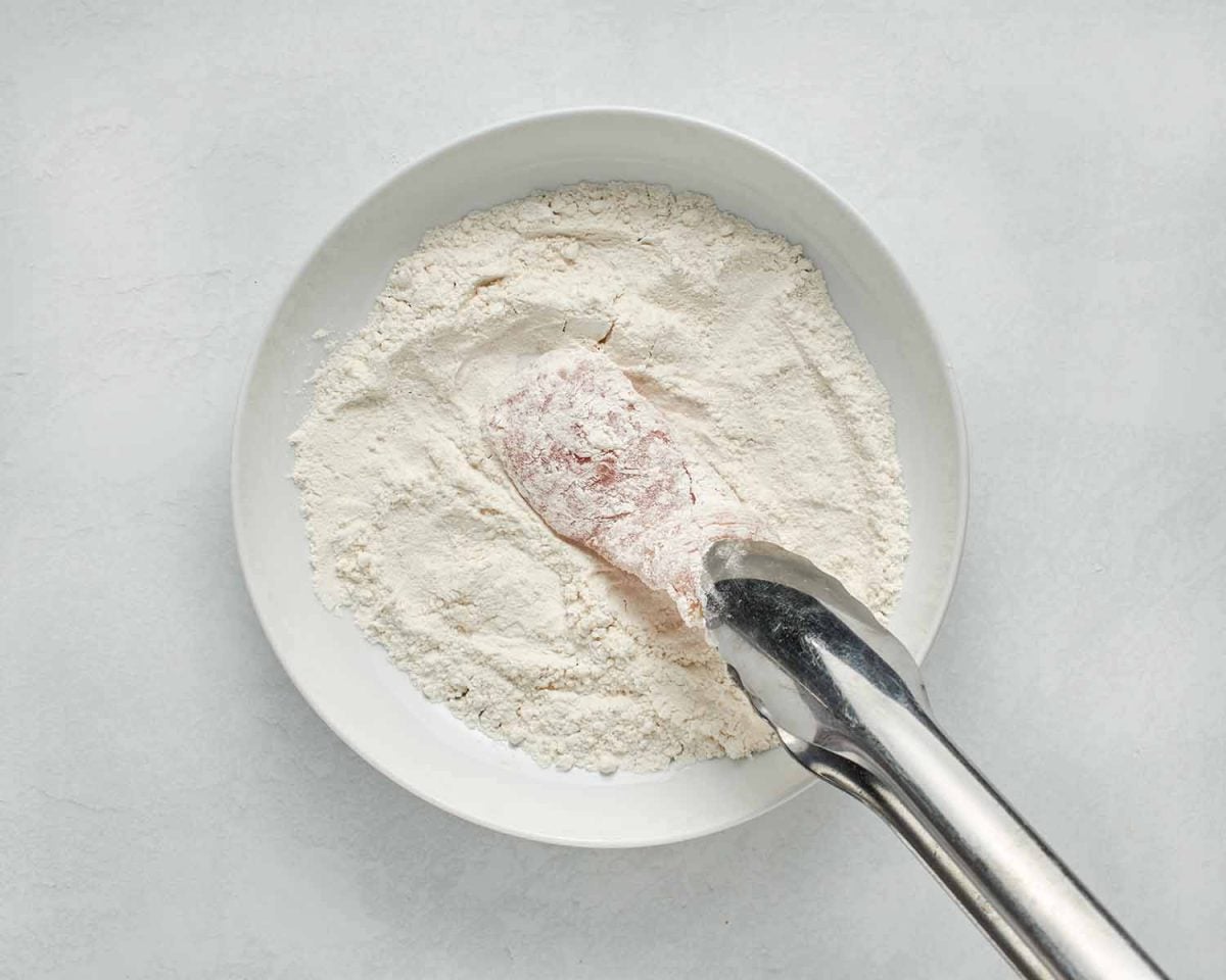 coating the chicken with flour.