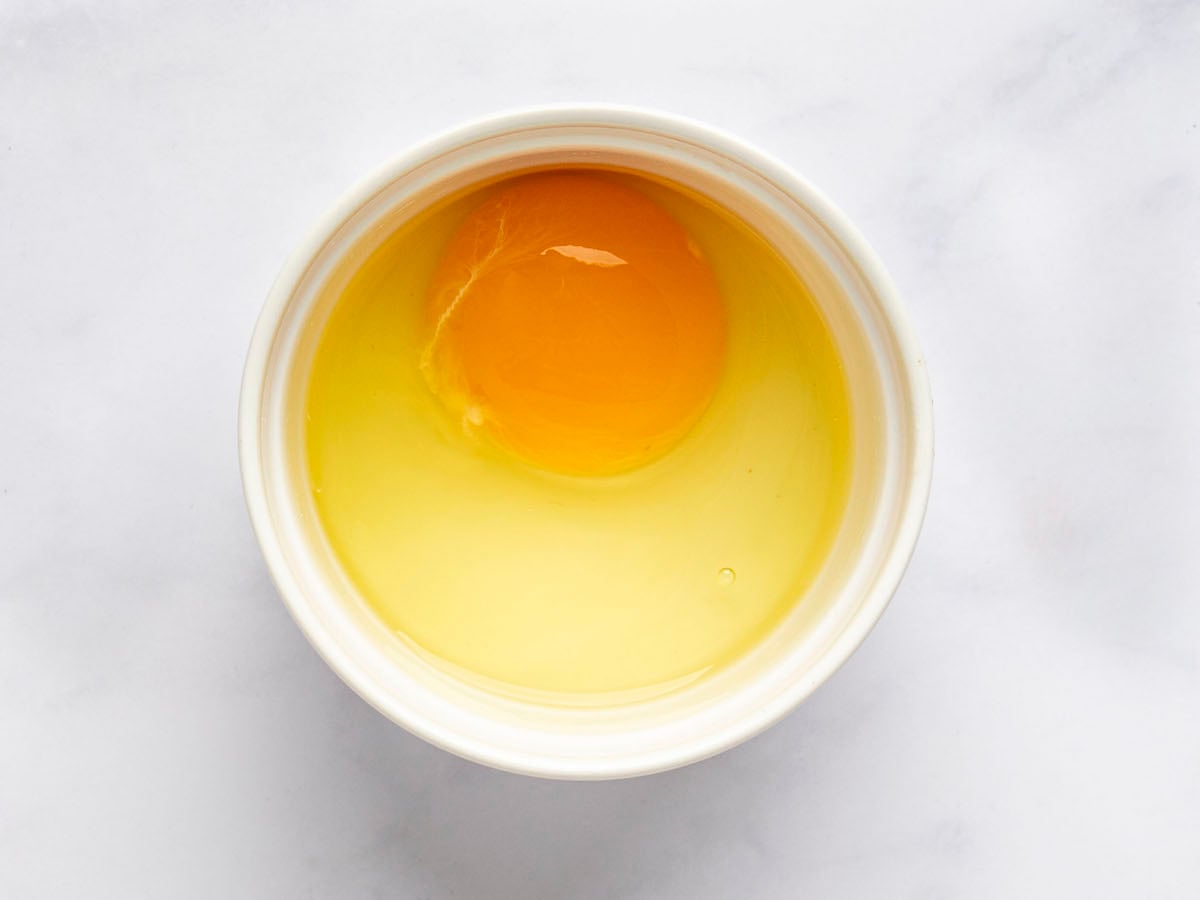 egg cracked into s small bowl