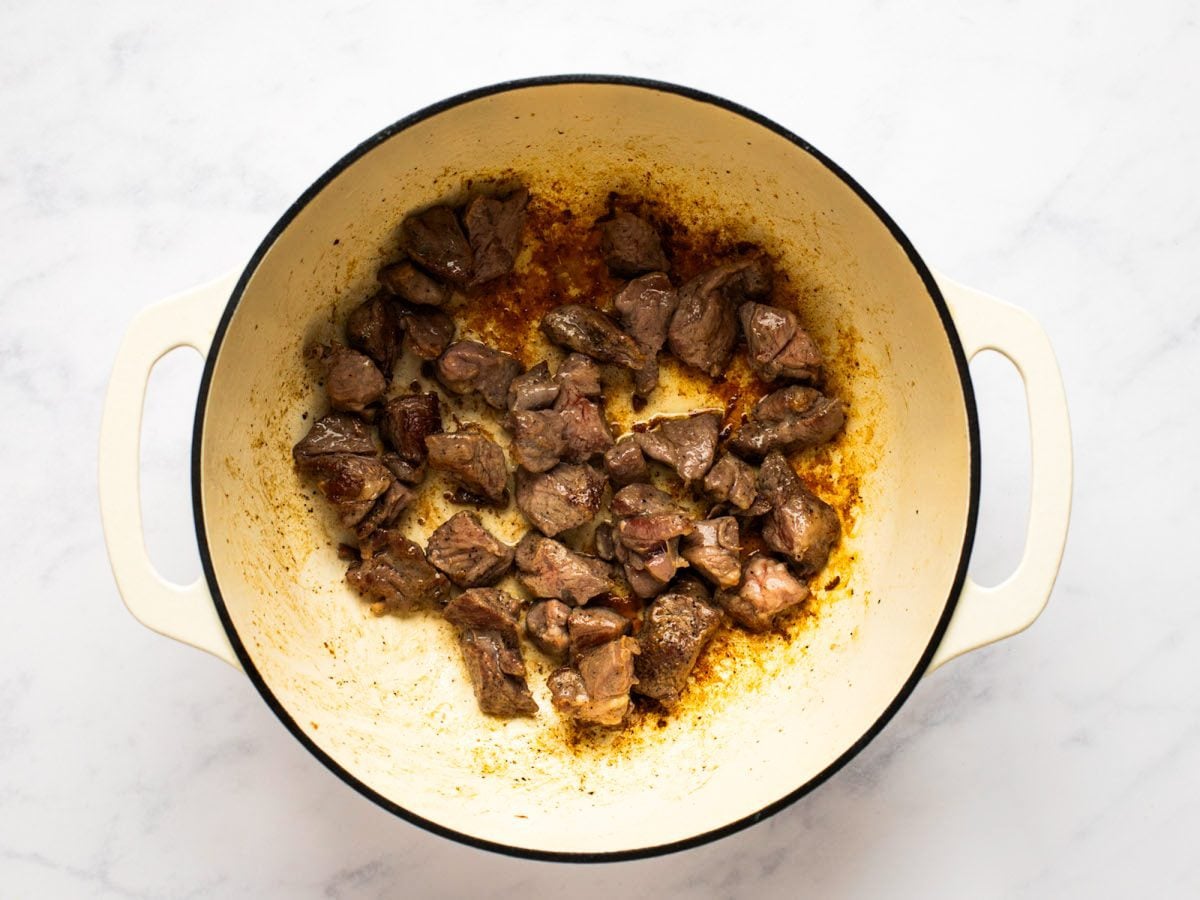 seared lamb pieces in Dutch oven