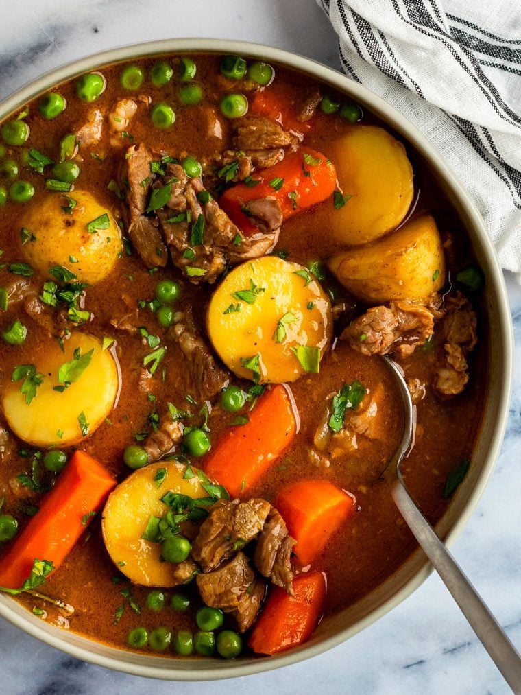 lamb stew in bowl with striped napkin